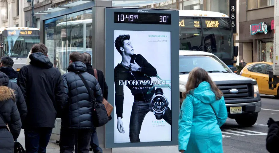 Emporio Armani campaign on a backlit transit shelter on a New York sidewalk.