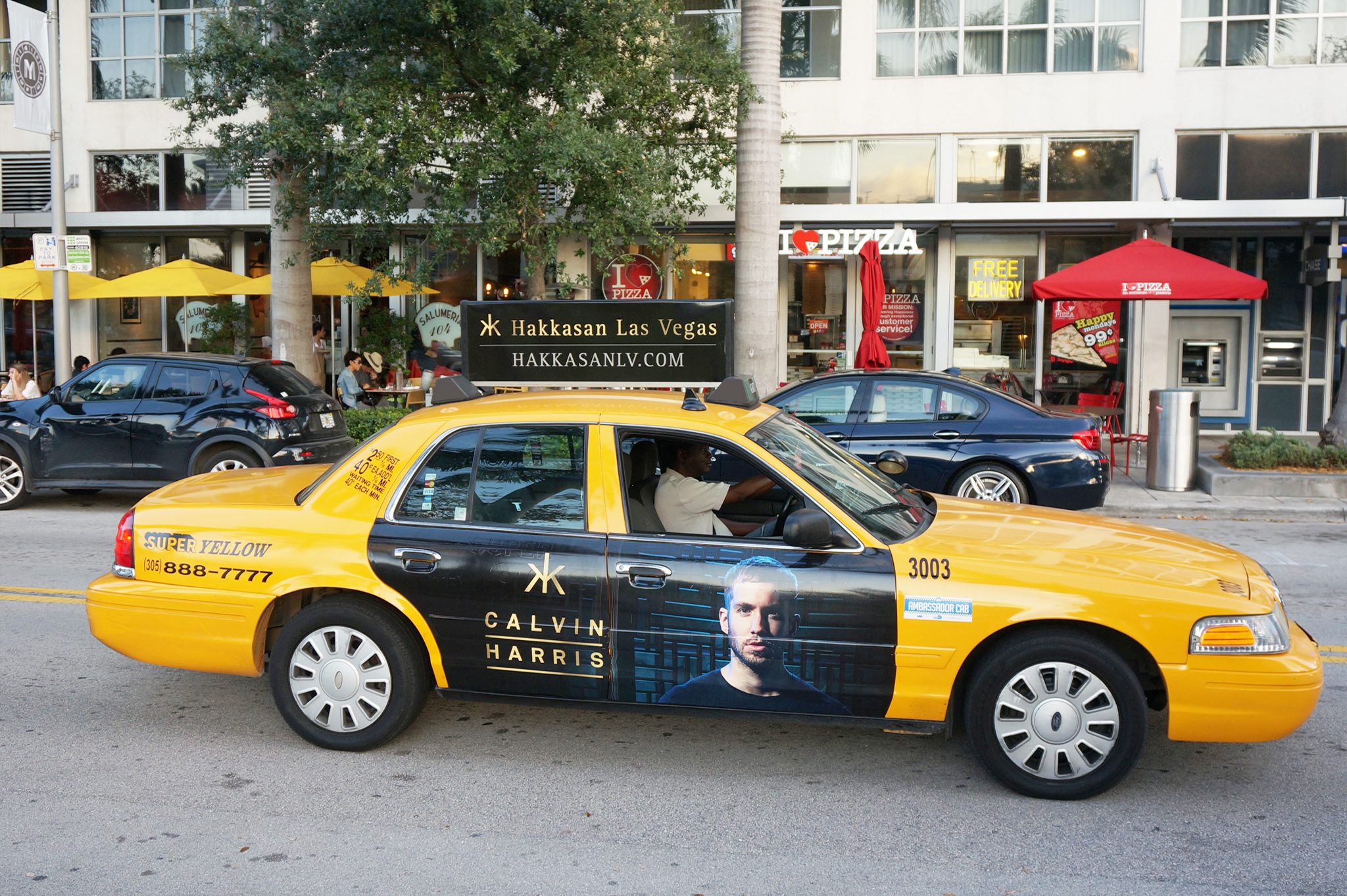 Hakkasan taxi wrap driving through a city street, brightened for visibility.