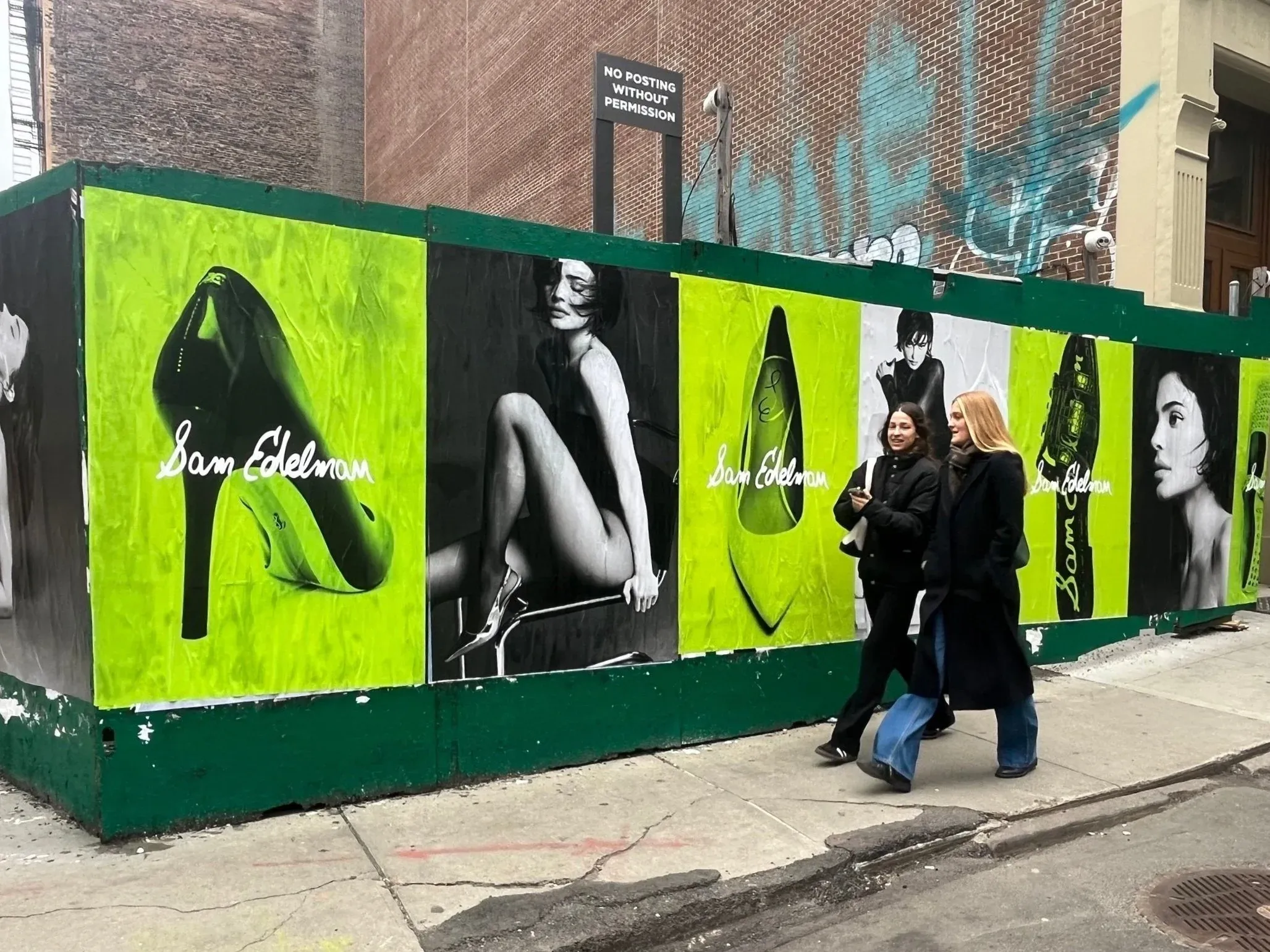 Sam Edelman wheatpaste posters layered across a New York construction wall.