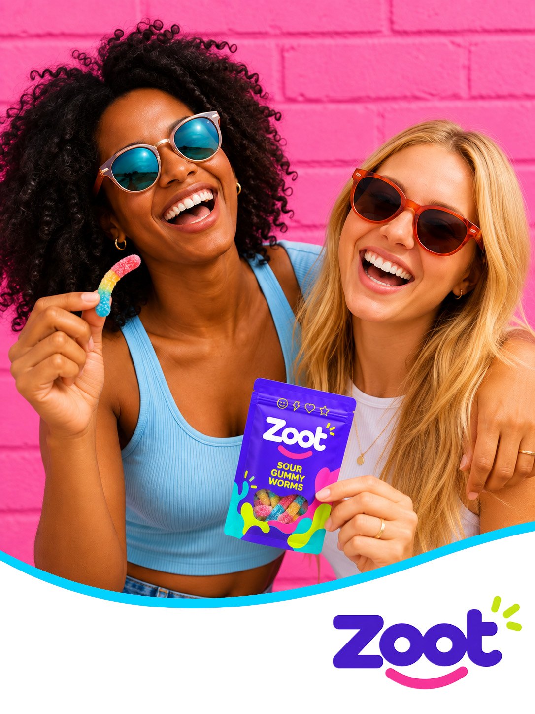 Two friends laughing in sunglasses with a bag of Zoot gummies against a bright pink wall.